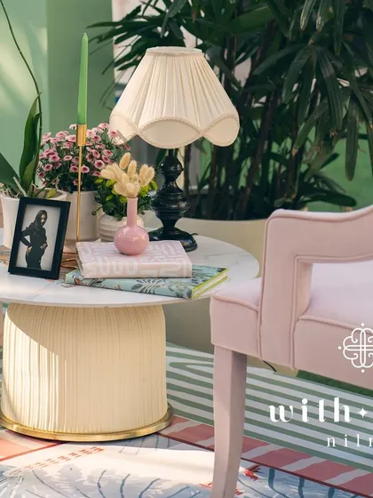 A cozy corner in 'The Conservatory', with plush pink chairs and a modern table.