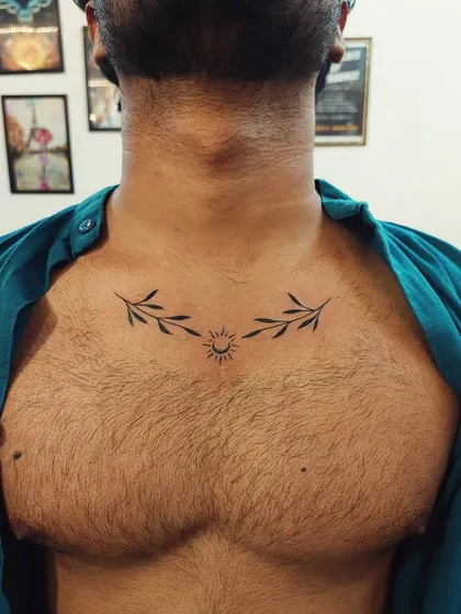 A symmetrical chest piece featuring a minimalist sun and two olive branches, symbolizing peace and new beginnings.