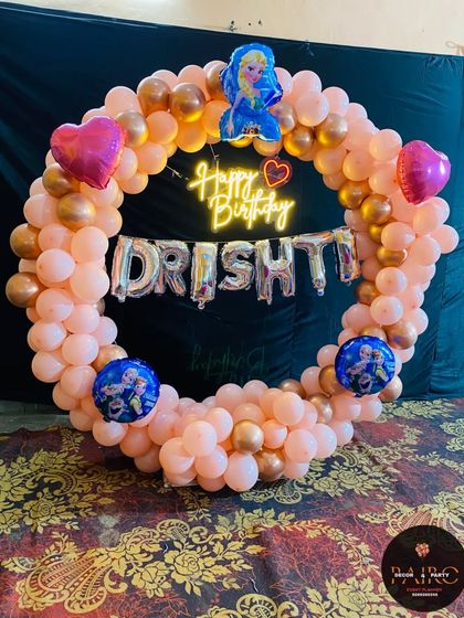 Another shot of the Frozen-themed balloon ring. The "Happy Birthday" neon sign and character balloons are clearly visible, making it a great photo spot.