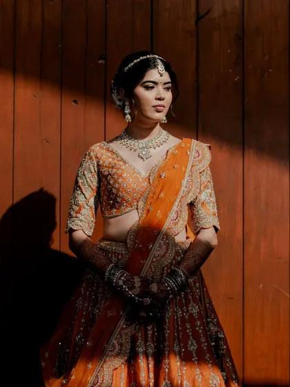 An artistic shot of Reeya, with sunlight and shadows playing on her face. Her makeup looks flawless and dimensional even in dramatic lighting.