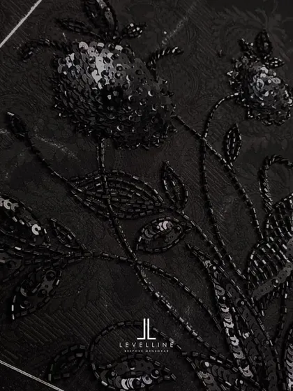 The intricate, hand-beaded embroidery on a black jacquard fabric. This is a sneak peek at the level of detail we can incorporate into our ceremonial pieces.