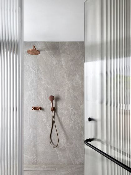 We used fluted glass and bronze-finished fixtures in this shower at the Mango Orchard House to create a sense of understated elegance and to play with light and texture.