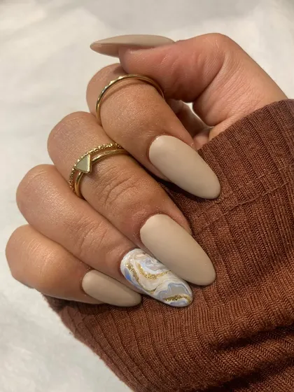 Matte it is. This beautiful set features a soft, beige matte polish with a single accent nail in a sophisticated marble design.
