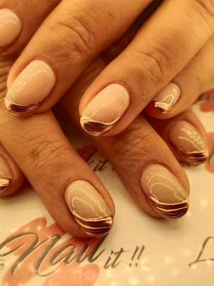 A chic French manicure with a metallic rose gold tip on a natural, glossy base.