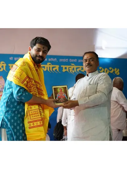 Receiving a memento and blessings from the organizers of the Diwali Pahat festival in Alandi.