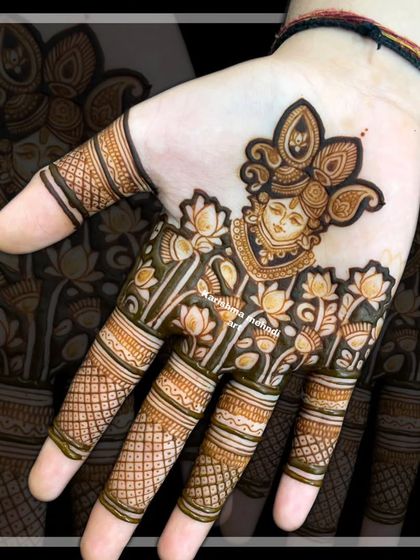 A portrait of Shreenath ji, intricately drawn on the palm and surrounded by delicate lotus flowers. This design is perfect for brides who wish to incorporate spiritual figures into their bridal henna.