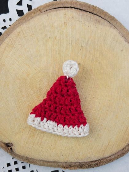A single Santa cap earring, perfect for customizing as a brooch or magnet as well.