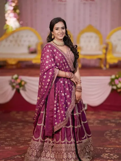 A beautiful solo portrait of the bride-to-be at her engagement ceremony, showcasing her stunning purple lehenga and elegant jewelry.
