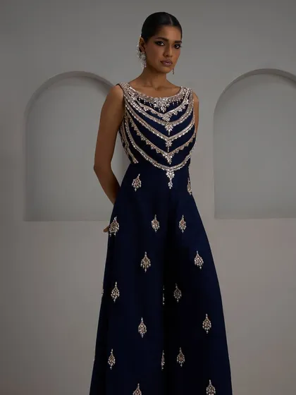 For evenings that call for drama and elegance, this navy blue jumpsuit is the perfect choice. The intricately embroidered bodice and flowing wide-leg trousers create a powerful silhouette that is both modern and timeless.
