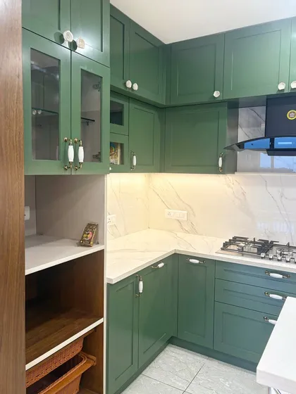 A different angle of the green kitchen from image 47, showing the corner layout and glass-fronted upper cabinets.