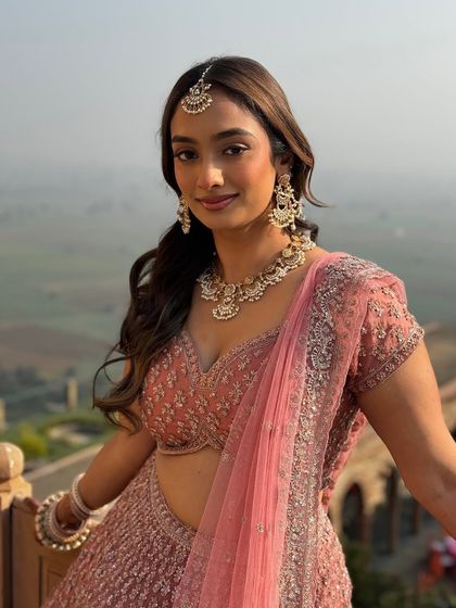 A simple yet stunning open hairstyle with a center part and face framing layers. This look is perfect for a bride who wants a natural and minimalist style.