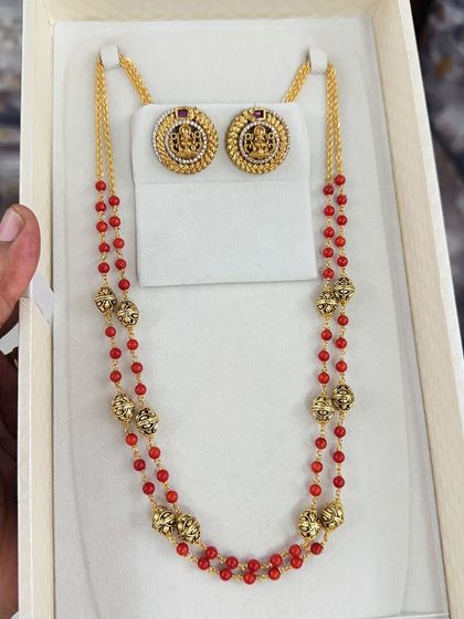 This traditional beaded set features red beads accented with ornate golden beads. The matching earrings have a temple-style design, making this set perfect for religious ceremonies and festivals.