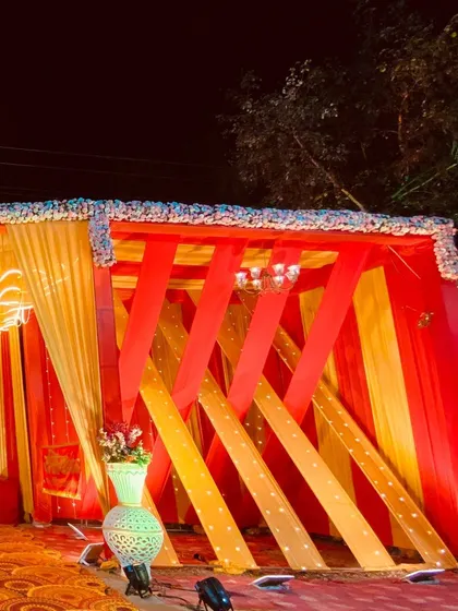 A side structure featuring a creative use of red and yellow fabric strips, adding a modern design element to the event space.