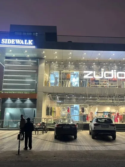 The storefront of 'The Sidewalk' at night, with the large glass panels offering a clear view into the Zudio retail outlet. My design prioritized visibility and a modern aesthetic to attract customers.