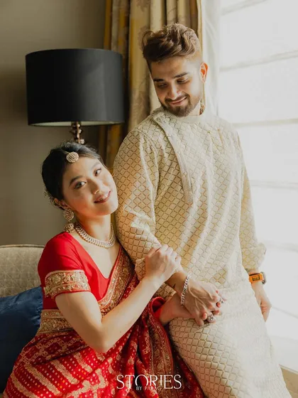 A candid and sweet moment captured by the window. This photo shows the couple's natural interaction and affection, using soft, natural light to create a gentle and romantic scene.