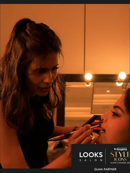 An intimate, behind-the-scenes shot of one of my artists perfecting a lip color backstage. This is where the magic happens, with intense focus on every detail before the show begins.