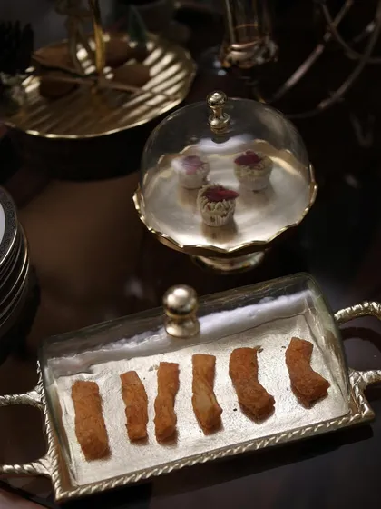 A duo of our elegant serving pieces. The rectangular tray and the small dessert stand, both with glass cloches, are perfect for creating a sophisticated and coordinated grazing table.