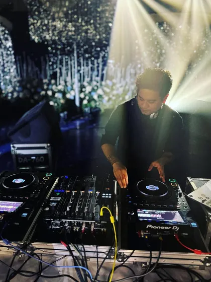 Bringing happiness through sound. This shot captures me at my console under the stage lights, focused on delivering a perfect mix for the crowd.