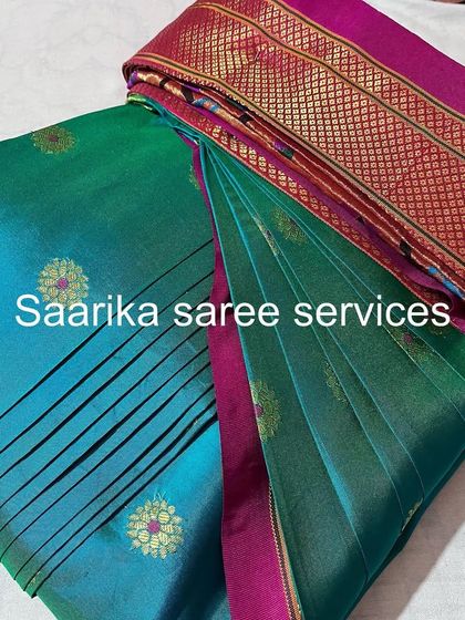 A lovely teal and pink silk saree, pleated and ready for a celebration.