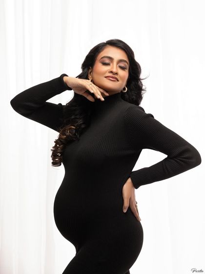 A chic and confident pose, highlighting her beautiful features and the elegant lines of the dress.