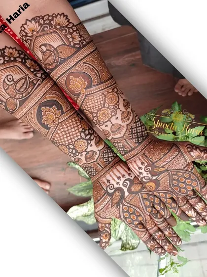 A heavy Indian design covering the full hands and arms. This intricate piece features multiple traditional elements, including peacocks, lotuses, and various geometric bands.