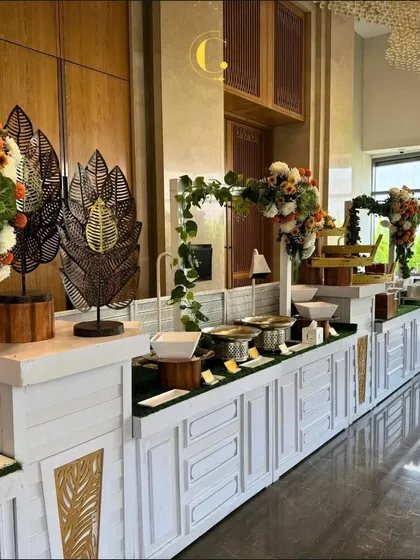 We believe the buffet should be a centerpiece of your event's decor. This elegant all-white setup, accented with lush greenery and artistic leaf sculptures, demonstrates how we integrate our culinary offerings into a seamless and sophisticated visual experience.