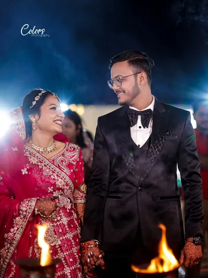 A candid shot of the couple sharing a look of love during their reception, framed by torches for a dramatic effect.
