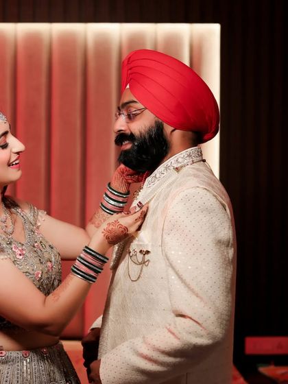 A heartwarming moment between the bride and groom as she helps him adjust his collar. This candid shot captures their care for each other during the getting-ready process.