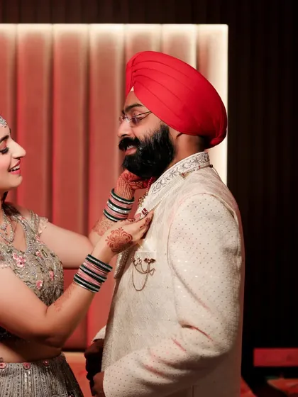 A heartwarming moment between the bride and groom as she helps him adjust his collar. This candid shot captures their care for each other during the getting-ready process.