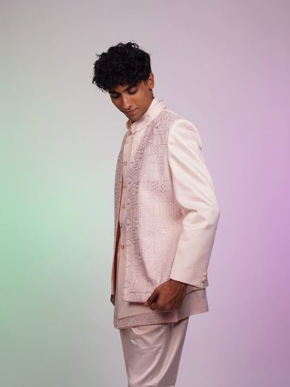 A side view of the pastel pink Indo-Western set, showing how the layered jacket creates a unique and stylish silhouette.