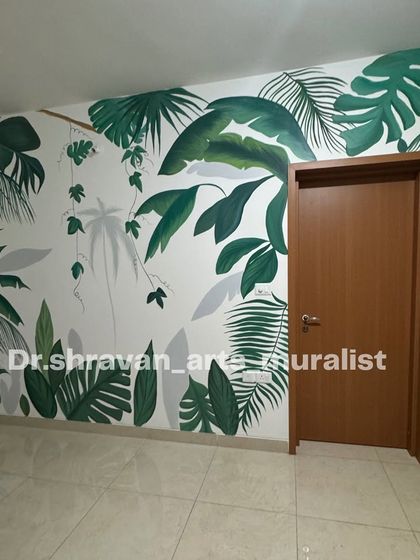 A simple yet effective tropical mural in a bedroom. The clean lines and solid colors of the leaves against the white wall make the room feel fresh and modern.