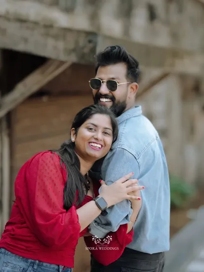 A happy, hugging portrait of the couple, their bright smiles directed at the camera.