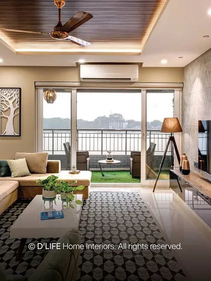 This living room features a beautiful view from the balcony, a comfortable L-shaped sofa, and a textured accent wall. The pendant lighting adds a modern, artistic touch.