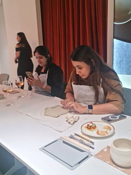Our workshops are not just about pottery; they're about creating a relaxed and social atmosphere. Participants in our Women's Day event enjoy some refreshments while working on their clay creations.