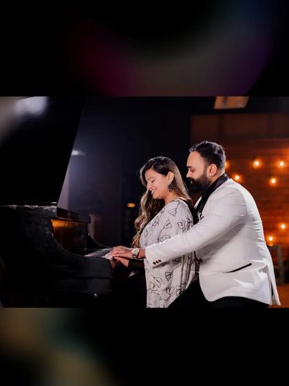 A close-up of a couple at the piano, with soft lighting creating a romantic mood. This shot focuses on their connection and the elegance of the setting.