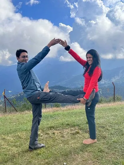 A creative partner pose forming a house shape. Yoga can be playful, and practicing with a partner in nature adds an element of fun and creativity to the journey.