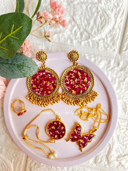 A full set of my real rose petal resin jewelry, including statement earrings, a delicate bracelet, a ring, and a butterfly pendant.