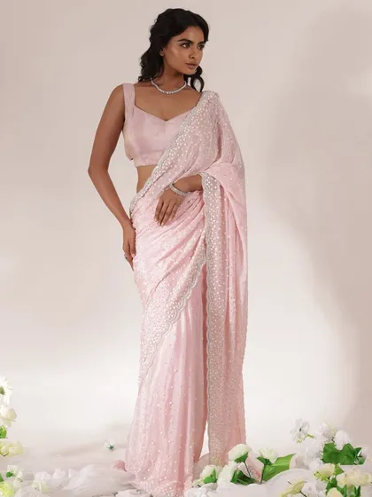 A full-length shot of the pink sequined saree, showcasing its beautiful drape. This look is perfect for someone who wants to feel elegant and put-together at a wedding celebration.