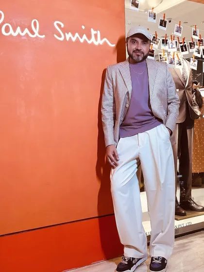 Attending a collection preview for Paul Smith. Here I am, styled in a pinstripe blazer and relaxed trousers, ready to explore the latest in sartorial menswear.