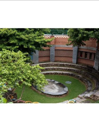 Viewed from above, the amphitheater forms a perfect circle, a core gathering space that grounds the campus design. It is embraced by the building and surrounding trees, creating a sheltered spot for community events.