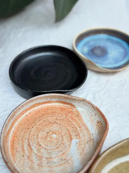 A variety of our spoon rests, showcasing different glazes like Shino, Rutile, and Tenmoku. There's a style for every kitchen.