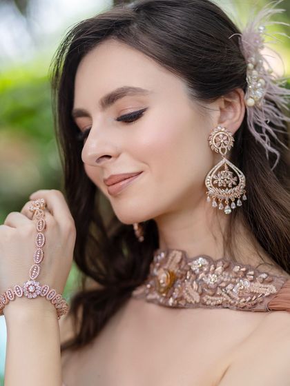 A close up on the details. The soft makeup is complemented by beautiful rose gold jewelry, including a delicate haath phool.