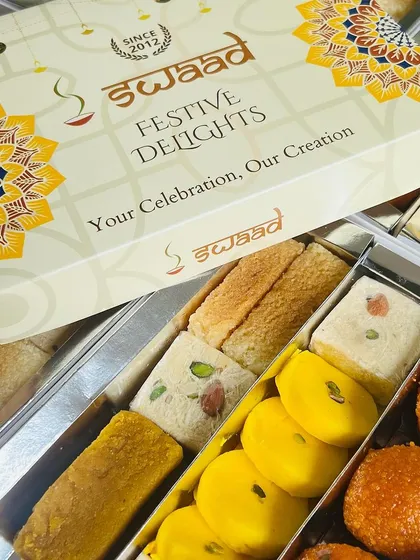 Here is our 'Festive Delights' assorted mithai box, opened to show the variety inside. We include a mix of our best sellers like Motichoor Ladoo, Peda, and Badam Pista Barfi, ensuring there's a favourite for everyone in your team or family.