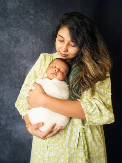 A mother's gentle embrace. This quiet, loving moment between a mom and her sleeping newborn is a beautiful testament to their special bond.