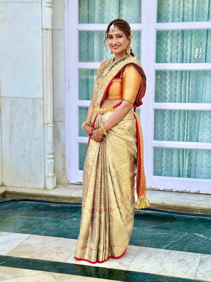 This bride looks serene and elegant in her golden pattu saree. The makeup is warm and glowing, with a classic red bindi and a soft brown lip.