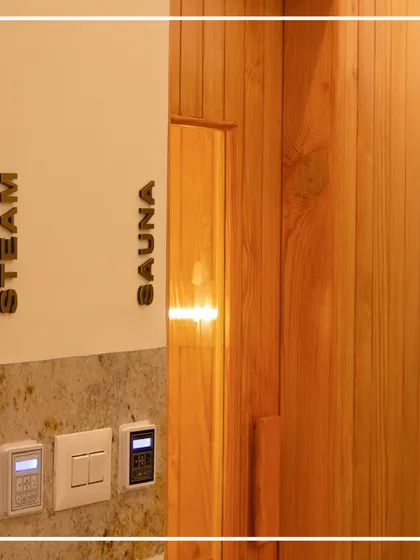 Modern wellness amenities, like these new steam and sauna rooms, are seamlessly integrated into the heritage setting of the Bangalore Club. The design uses warm wood paneling and clear signage to create a functional, spa-like experience that respects the original structure.