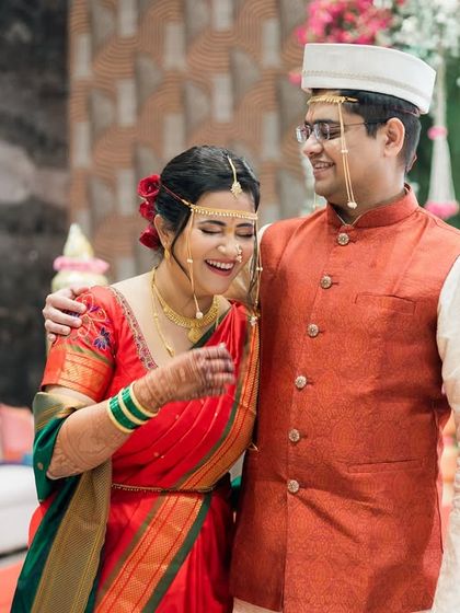 A candid shot of the couple sharing a laugh during their Maharashtrian wedding ceremony. The joy is absolutely contagious!