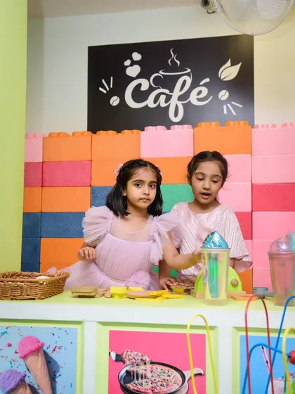 Two friends team up to run the pretend cafe, serving delicious imaginary drinks and snacks to their happy customers.