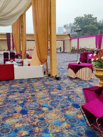 This image shows the combination of round dining tables and lounge areas within the same event space, all set up on a patterned carpet that covers the entire ground.