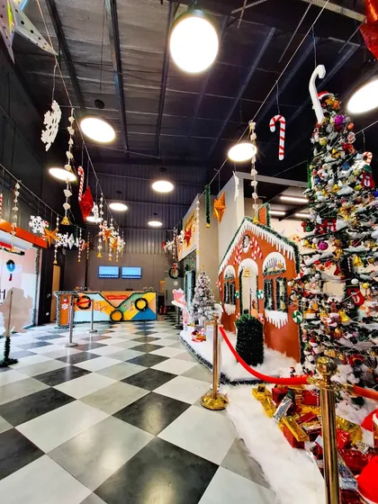A festive hallway during our Christmas celebration, complete with a gingerbread house, a large tree, and hanging decorations.